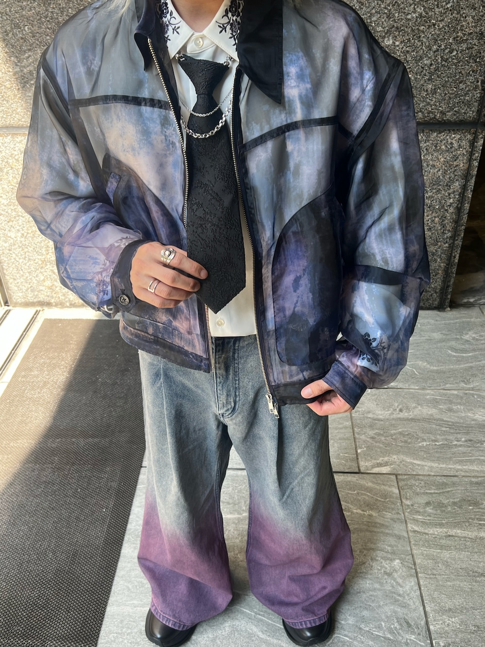 パープル系のデニムパンツ、パープル系のブルゾン、ホワイト系のシャツ/ブラウスを着用したメンズの冬コーディネートの2枚目の写真