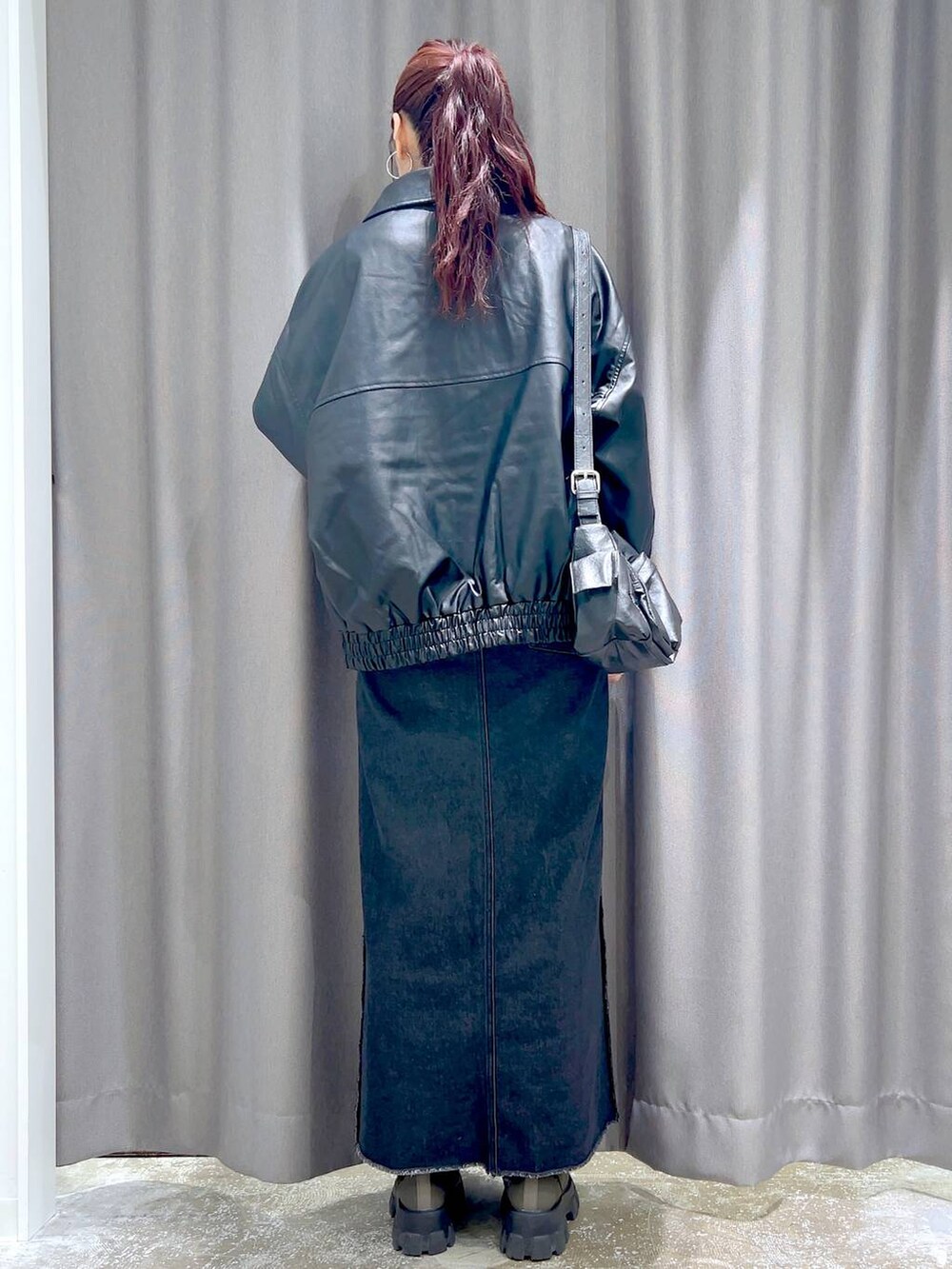 ブラック系のTシャツ/カットソー、ホワイト系のベスト、ブラック系のブルゾンを着用したレディースの秋コーディネートの3枚目の写真