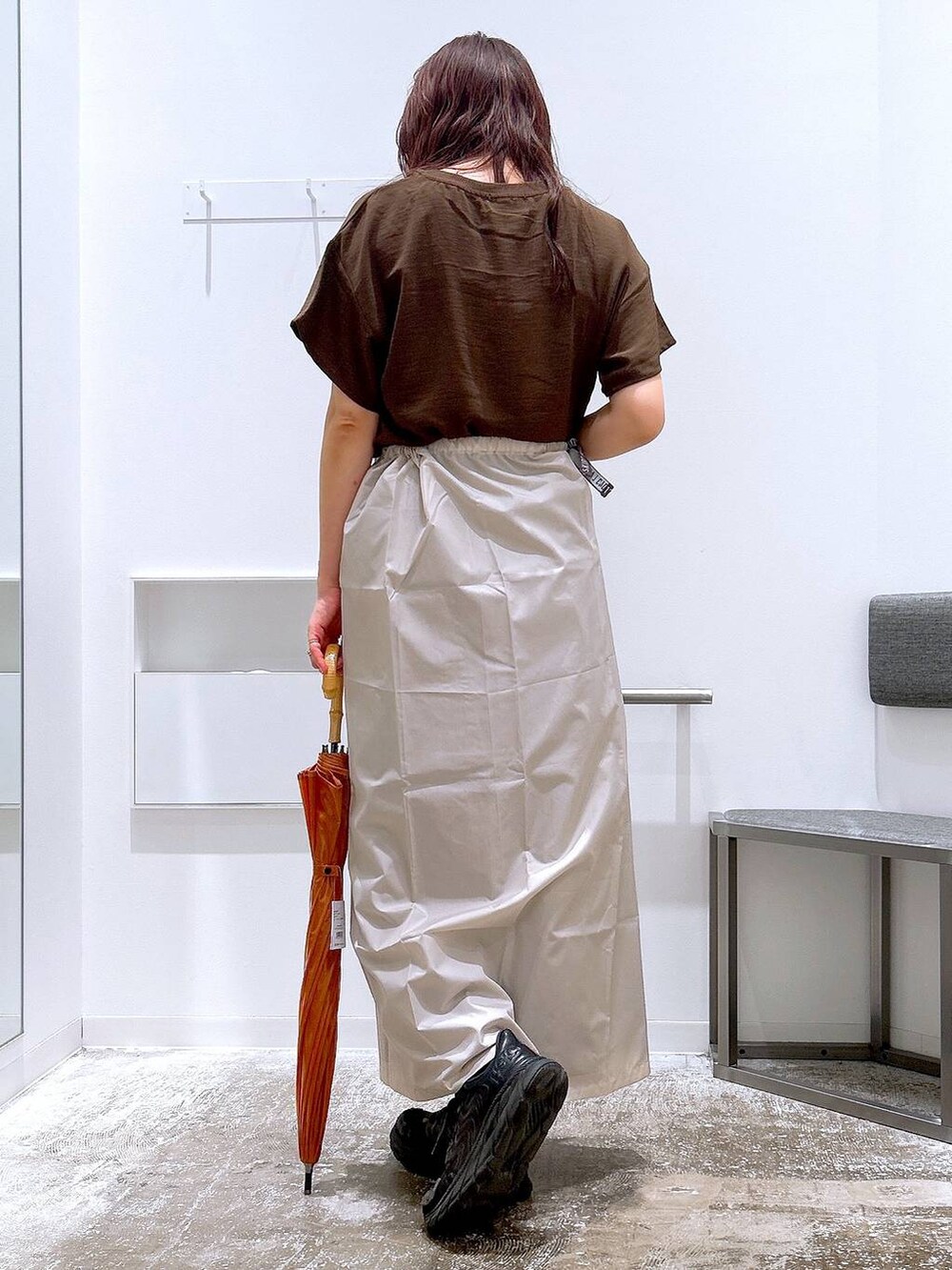 ブラウン系のスカート、ブラウン系のTシャツ/カットソー、ベージュ系のレインコート/ポンチョを着用したレディースの夏コーディネートの3枚目の写真