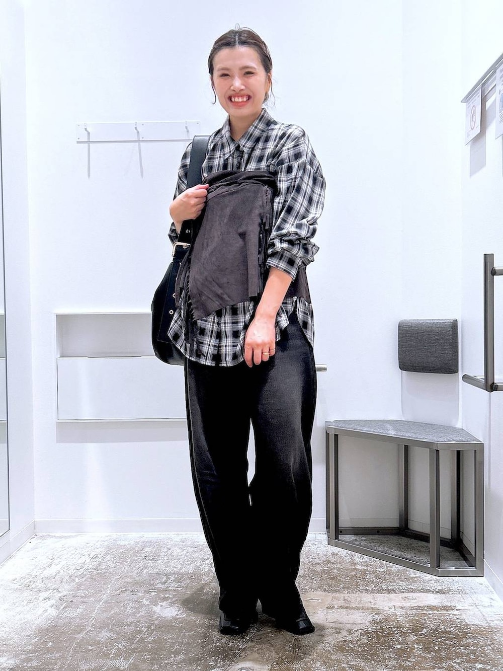ブラック系のデニムパンツ、ブラック系のショルダーバッグ、ブラック系のシャツ/ブラウスを着用したレディースの秋コーディネートの3枚目の写真