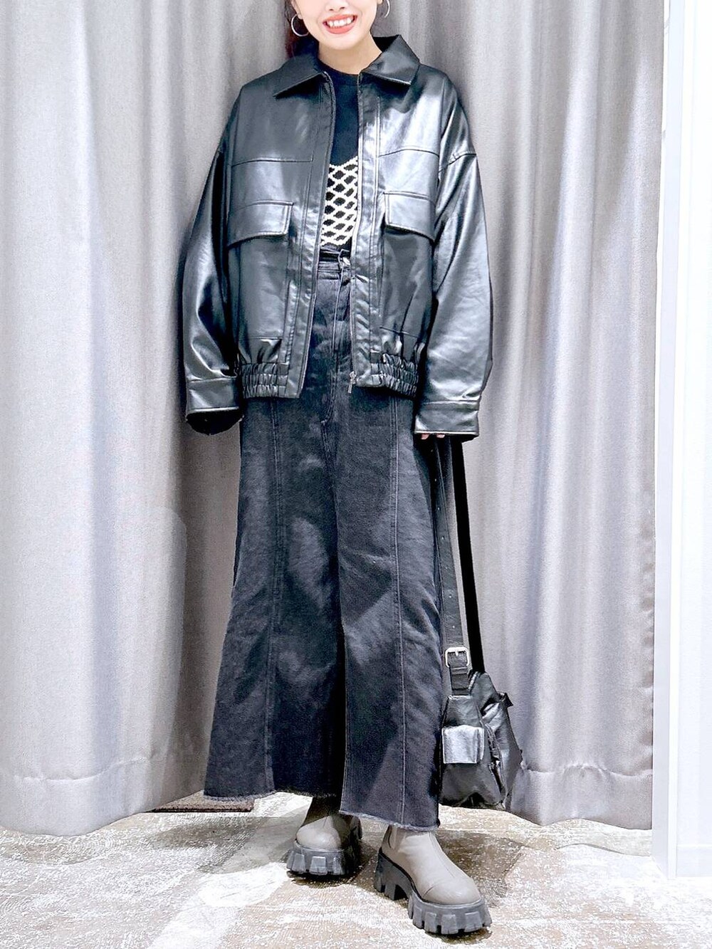 ブラック系のTシャツ/カットソー、ホワイト系のベスト、ブラック系のブルゾンを着用したレディースの秋コーディネートの2枚目の写真