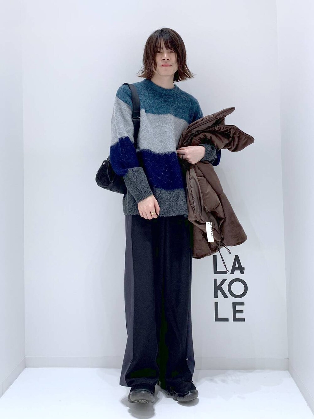 ベージュ系のショルダーバッグ、ブラック系のその他パンツ、ブルー系のニット/セーターを着用したメンズの秋コーディネートの2枚目の写真