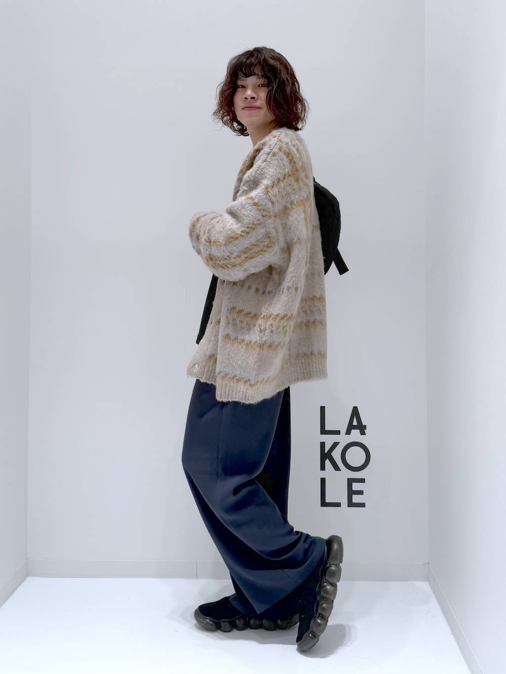 ベージュ系のカーディガン/ボレロ、ブラック系のショルダーバッグ、ブラック系のTシャツ/カットソーを着用したメンズの冬コーディネートの5枚目の写真