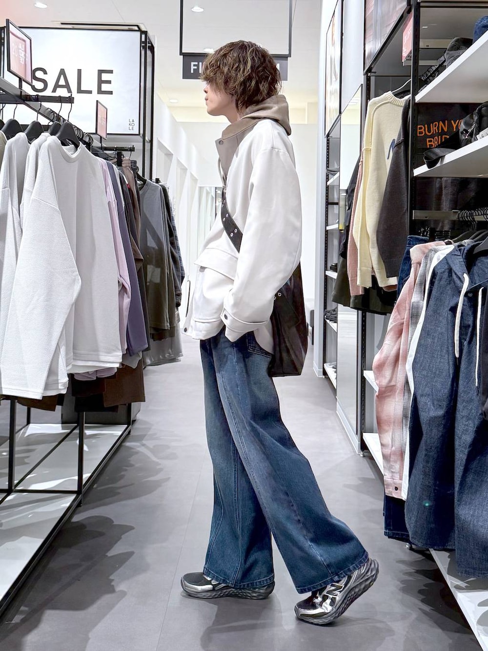 その他のスニーカー、ブラック系のショルダーバッグ、ブルー系のデニムパンツを着用したメンズの春コーディネートの4枚目の写真