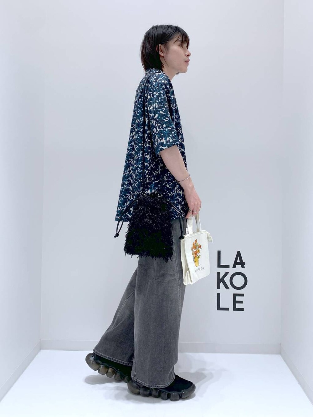 グリーン系のシャツ/ブラウス、ブラック系のショルダーバッグ、グレー系のデニムパンツを着用したメンズの秋コーディネートの2枚目の写真