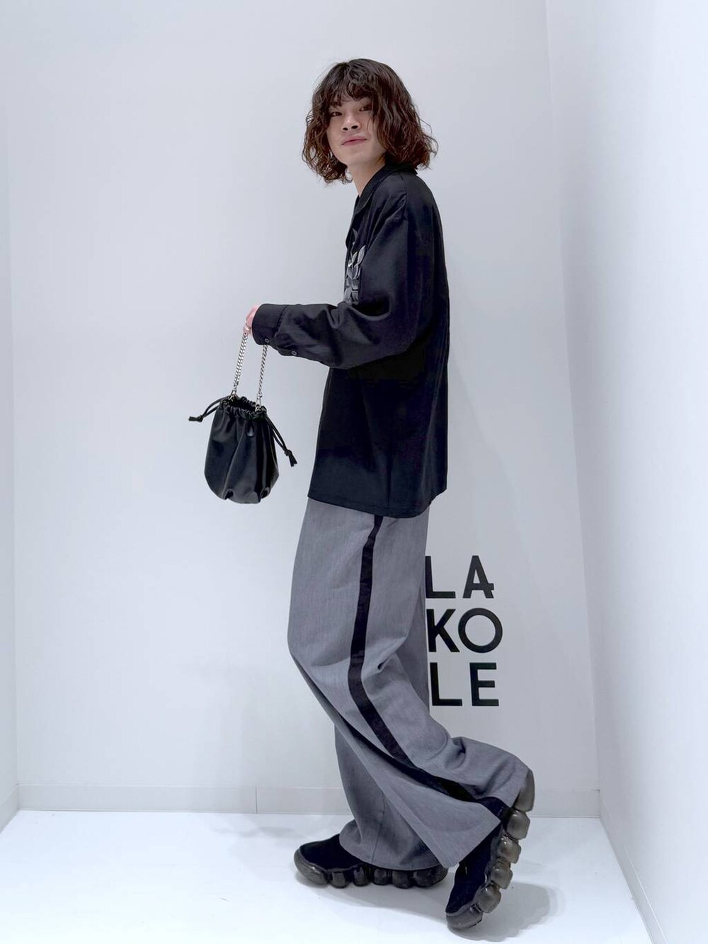 グレー系のスラックス、ブラック系のショルダーバッグ、ブラック系のシャツ/ブラウスを着用したメンズの冬コーディネートの4枚目の写真