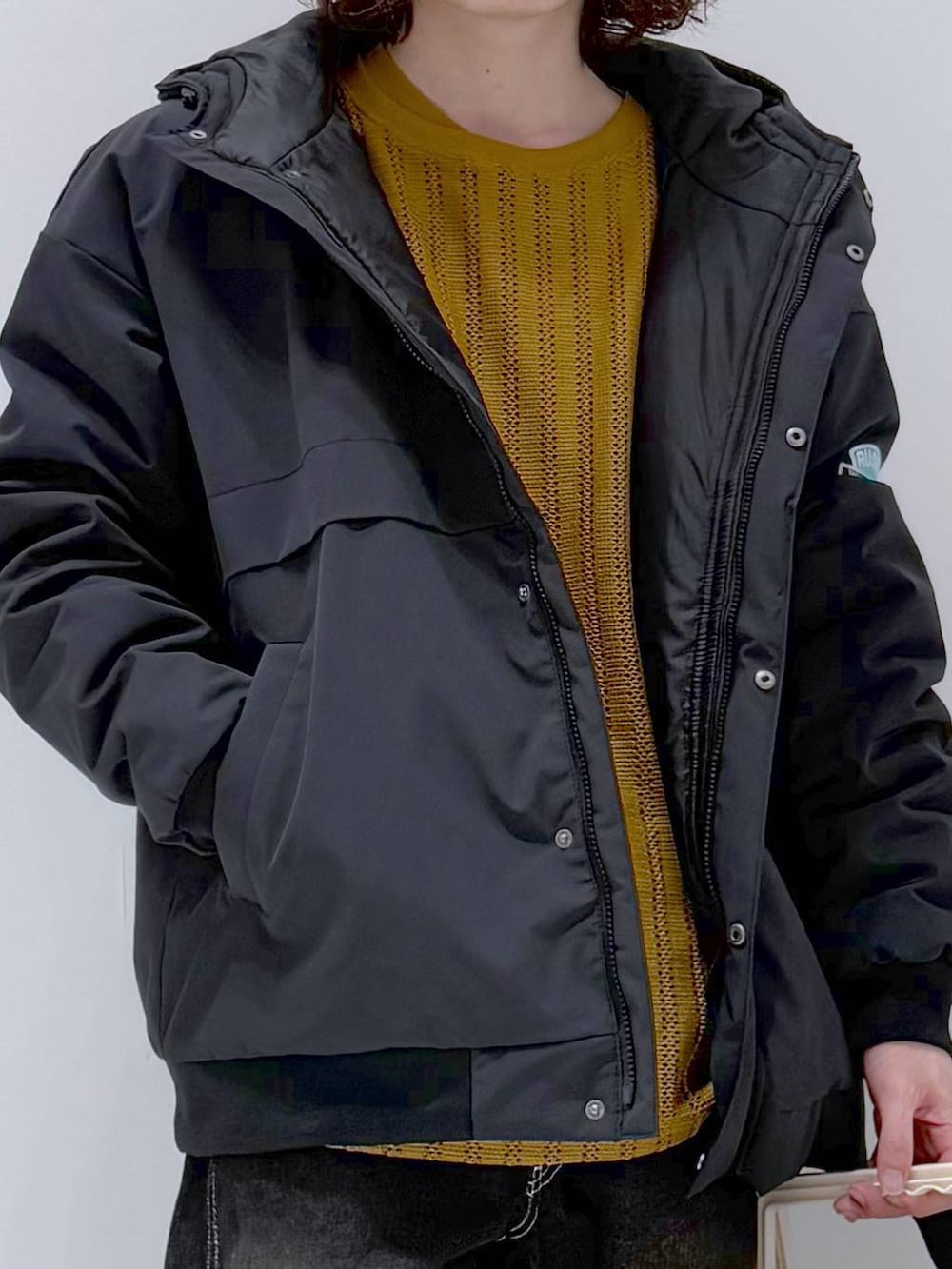イエロー系のTシャツ/カットソー、ブラック系のデニムパンツ、ブラック系のブルゾンを着用したメンズの冬コーディネートの6枚目の写真