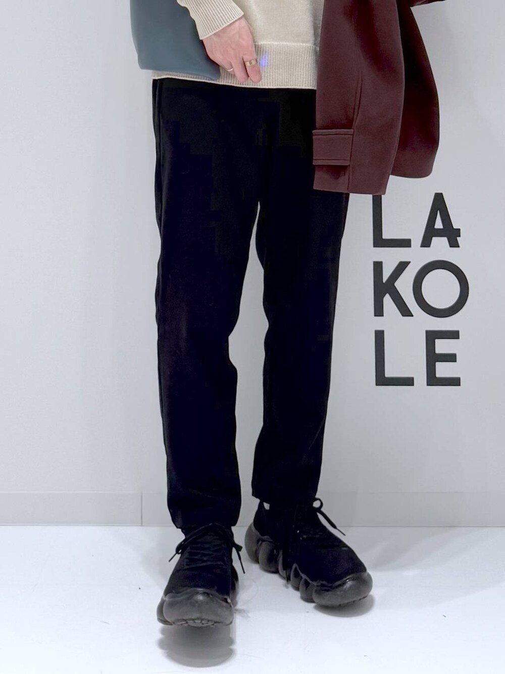 ブラウン系のブルゾン、ベージュ系のニット/セーター、ブルー系のトートバッグを着用したメンズの冬コーディネートの9枚目の写真