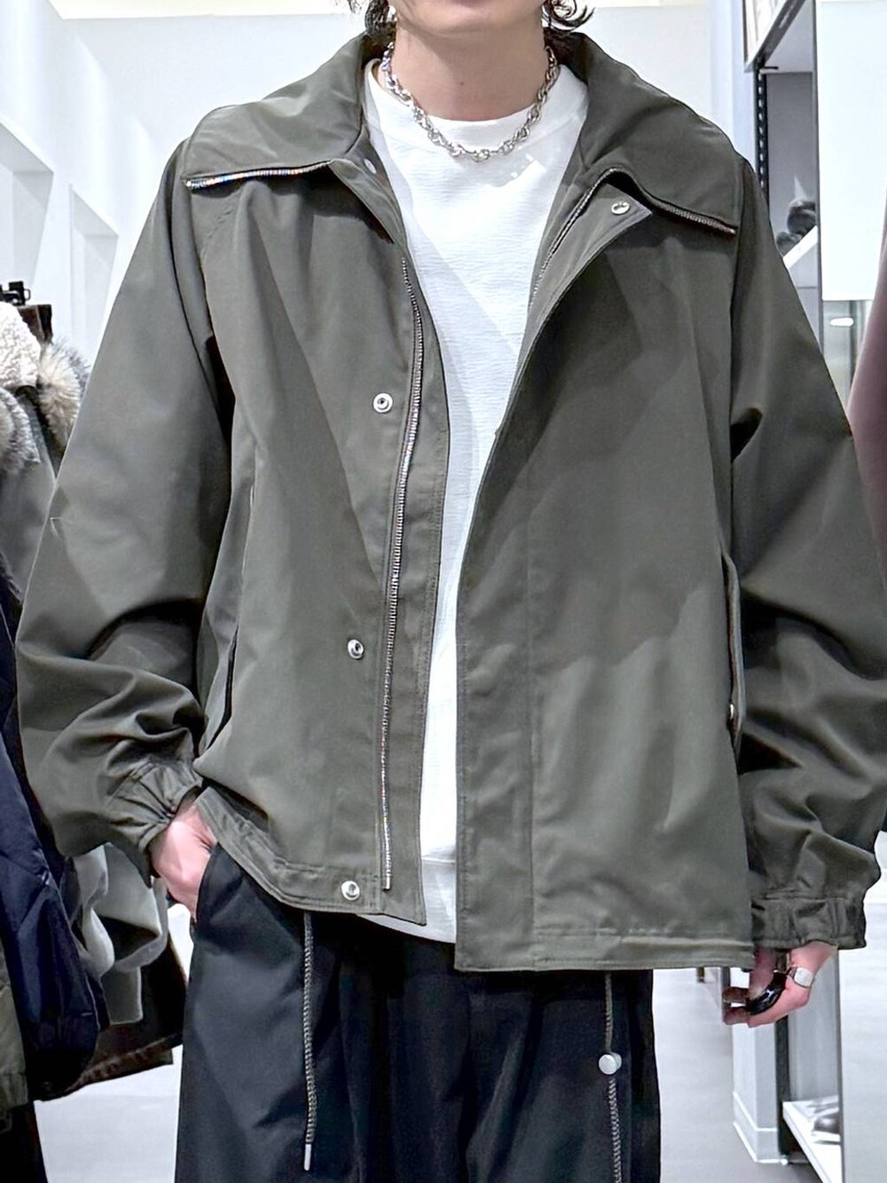 ホワイト系のスウェット、グリーン系のモッズコート、ブラック系のスニーカーを着用したメンズの冬コーディネートの5枚目の写真