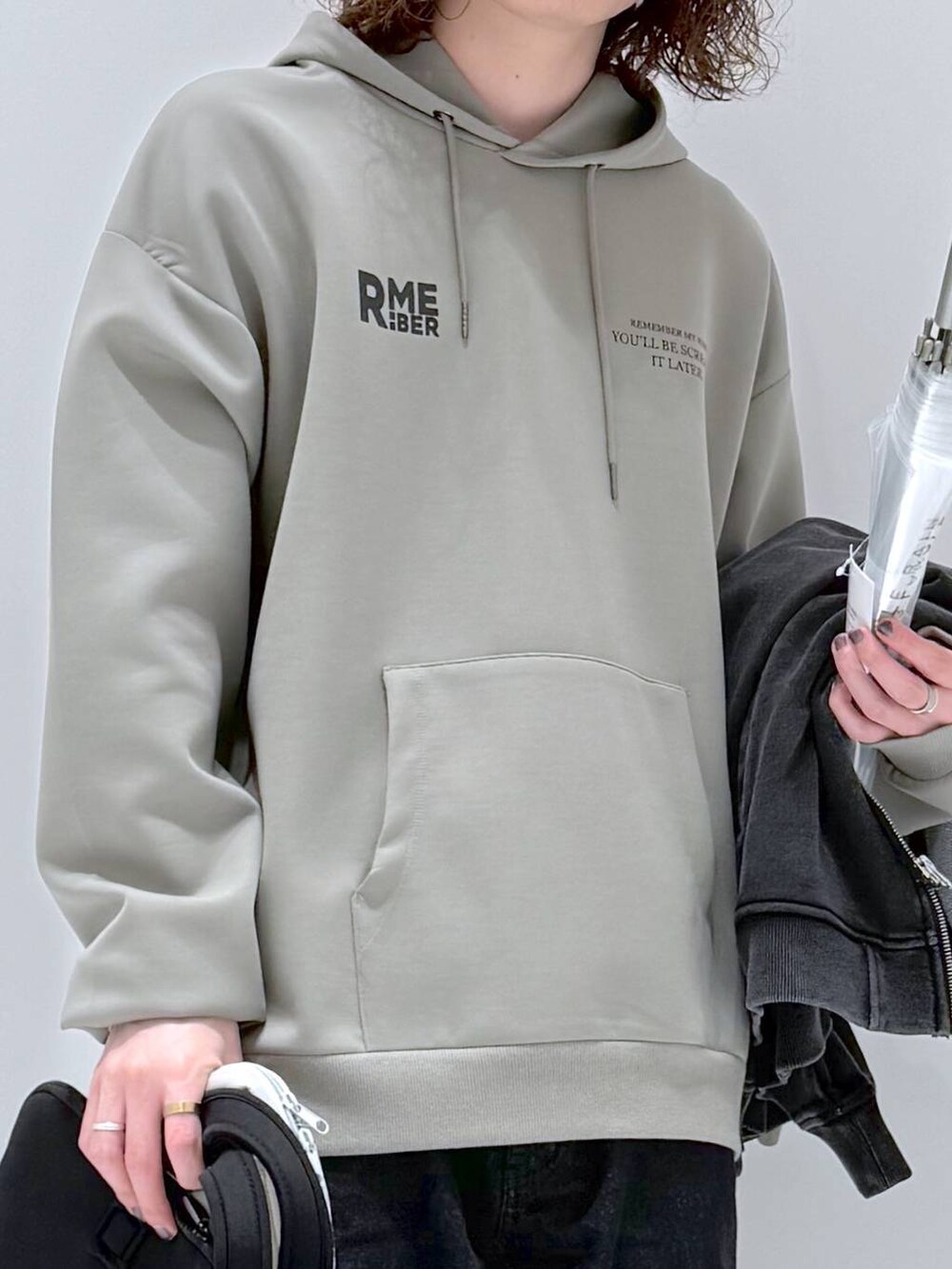 グリーン系のパーカー、グレー系のブルゾン、ブラック系のデニムパンツを着用したメンズの春コーディネートの8枚目の写真