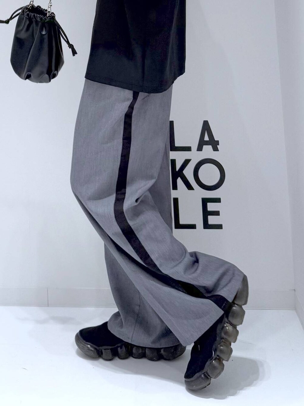 グレー系のスラックス、ブラック系のショルダーバッグ、ブラック系のシャツ/ブラウスを着用したメンズの冬コーディネートの6枚目の写真