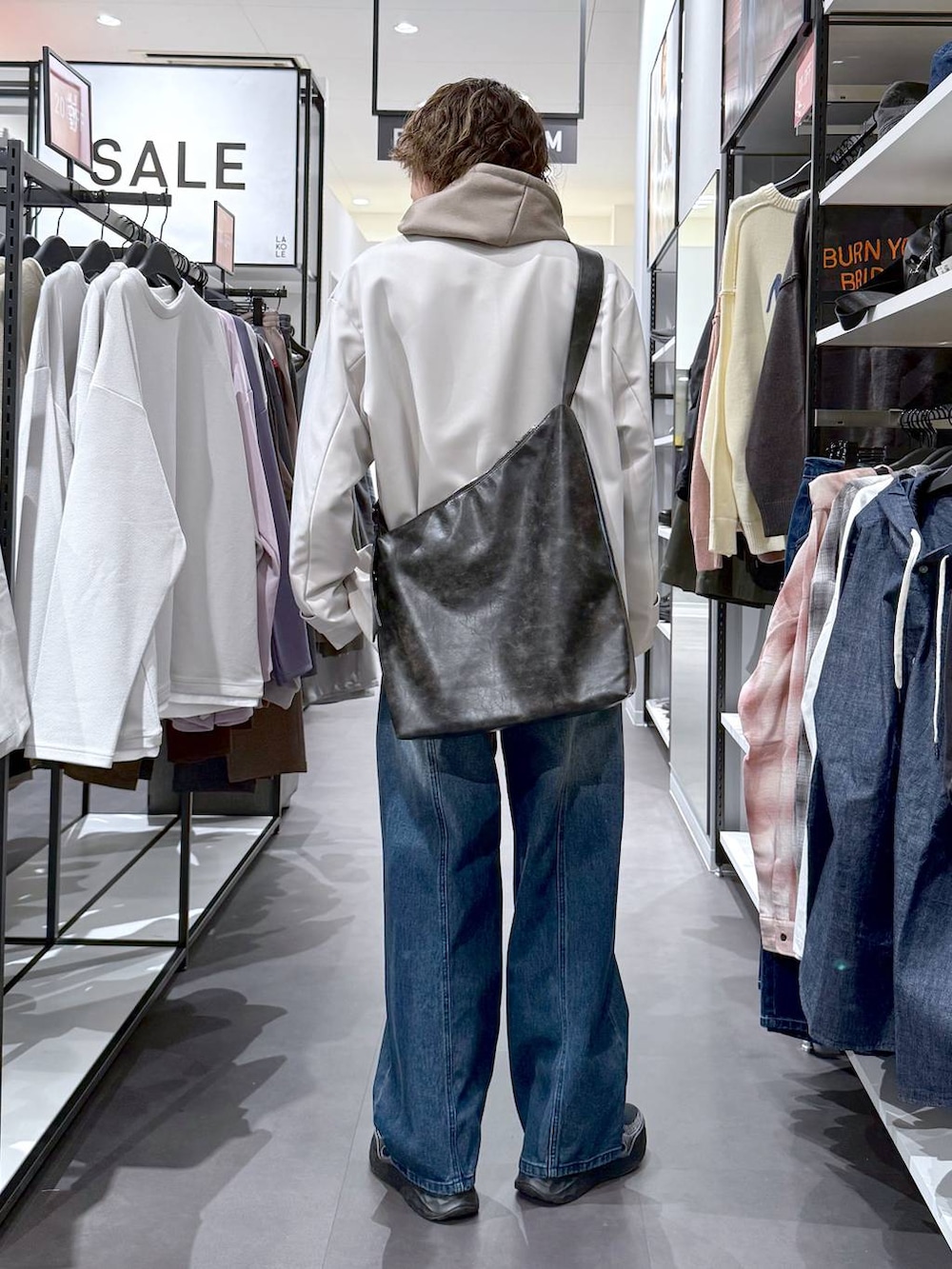 その他のスニーカー、ブラック系のショルダーバッグ、ブルー系のデニムパンツを着用したメンズの春コーディネートの3枚目の写真