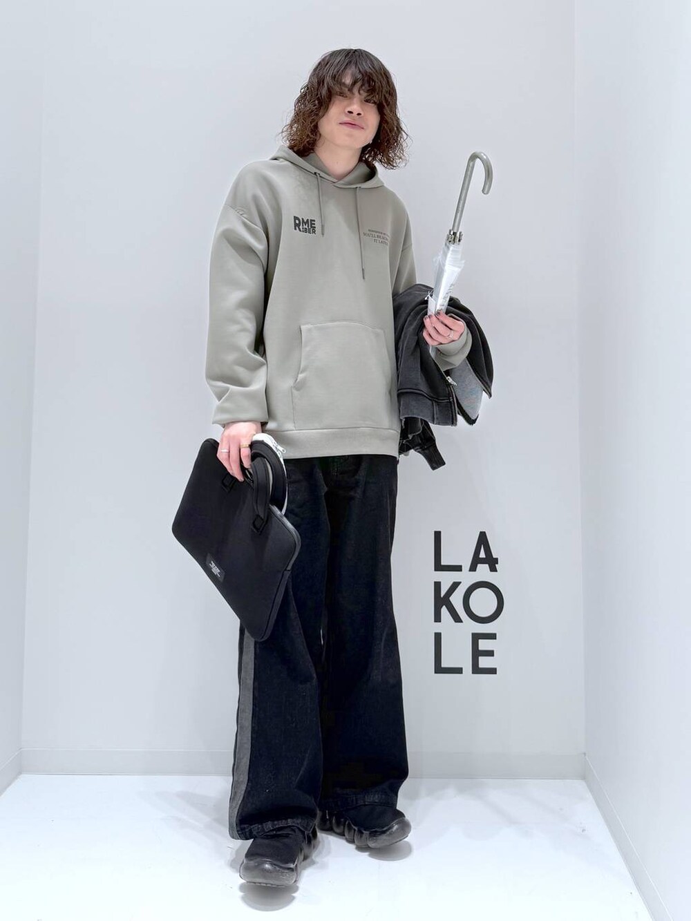 グリーン系のパーカー、グレー系のブルゾン、ブラック系のデニムパンツを着用したメンズの春コーディネートの2枚目の写真