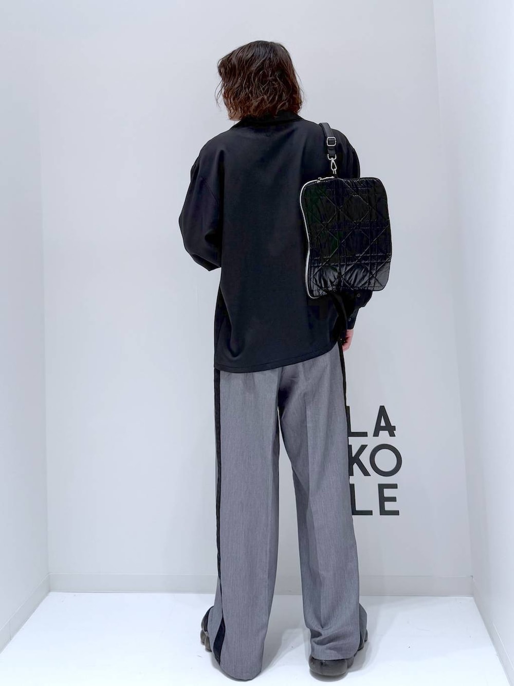 グレー系のスラックス、ブラック系のショルダーバッグ、ブラック系のシャツ/ブラウスを着用したメンズの冬コーディネートの3枚目の写真