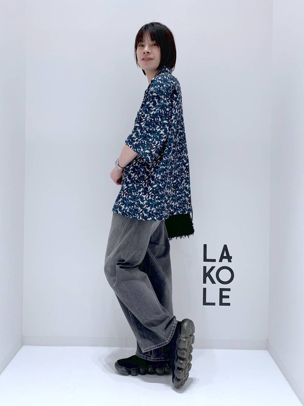 グリーン系のシャツ/ブラウス、ブラック系のショルダーバッグ、グレー系のデニムパンツを着用したメンズの秋コーディネートの4枚目の写真