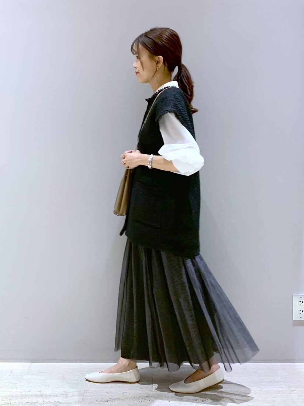 ホワイト系のパンプス、ベージュ系のショルダーバッグ、ホワイト系のシャツ/ブラウスを着用したレディースの秋コーディネートの2枚目の写真