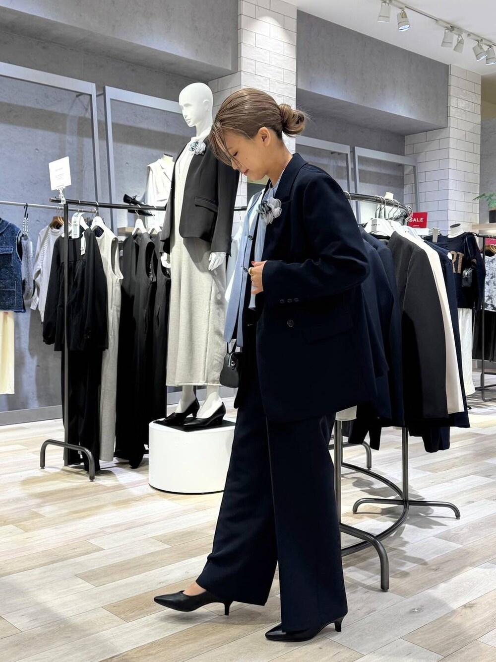 ブルー系のスーツパンツ、ブルー系のシャツ/ブラウス、ブラック系のパンプスを着用したレディースの冬コーディネートの2枚目の写真