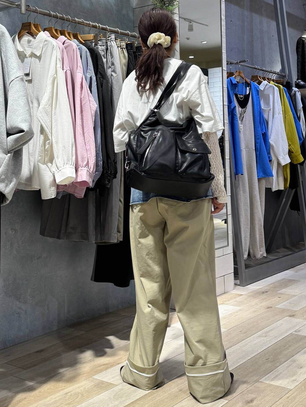 ブラック系のショルダーバッグ、ベージュ系のその他パンツ、ホワイト系のTシャツ/カットソーを着用したレディースの春コーディネートの3枚目の写真