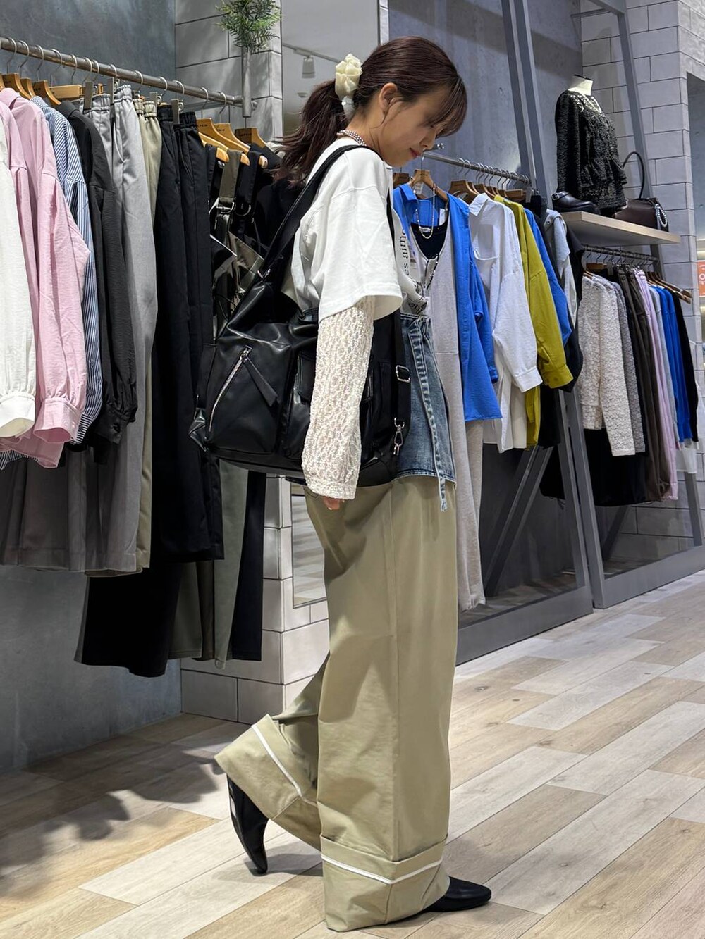 ブラック系のショルダーバッグ、ベージュ系のその他パンツ、ホワイト系のTシャツ/カットソーを着用したレディースの春コーディネートの4枚目の写真