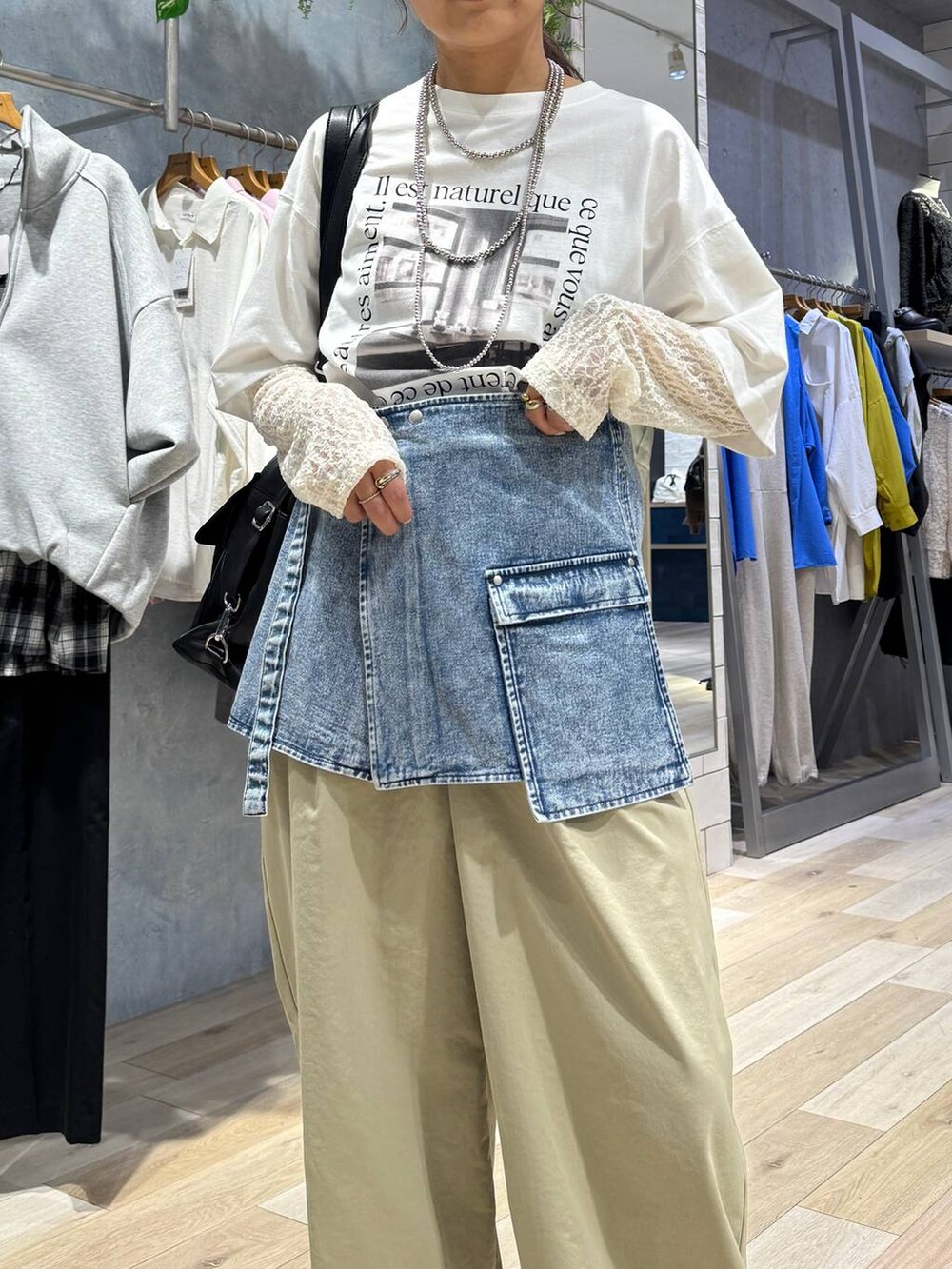 ブラック系のショルダーバッグ、ベージュ系のその他パンツ、ホワイト系のTシャツ/カットソーを着用したレディースの春コーディネートの5枚目の写真