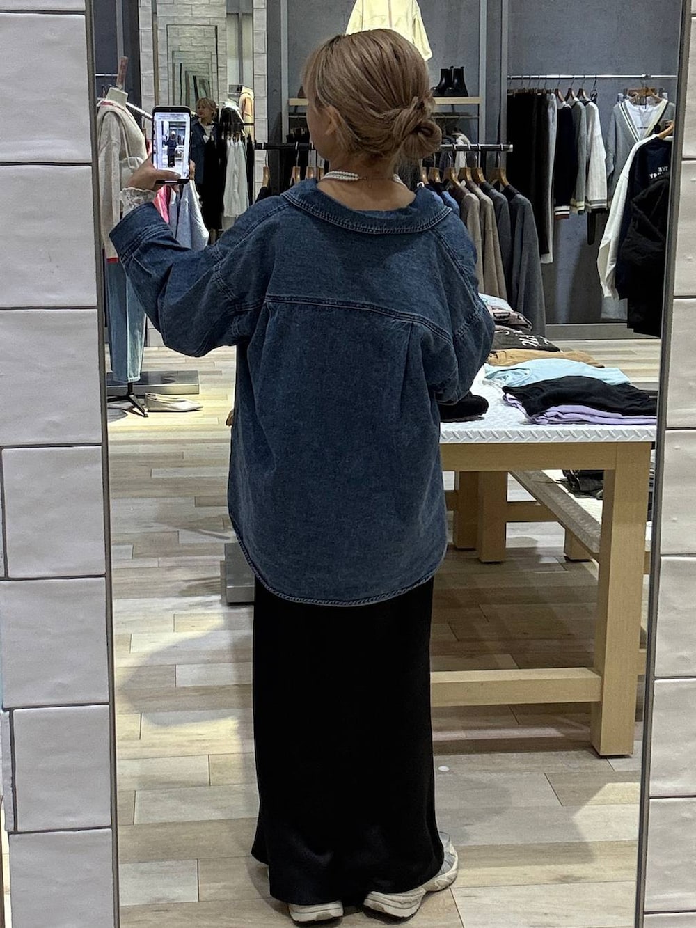 ブラック系のスカート、ブルー系のシャツ/ブラウス、ホワイト系のTシャツ/カットソーを着用したレディースの冬コーディネートの4枚目の写真