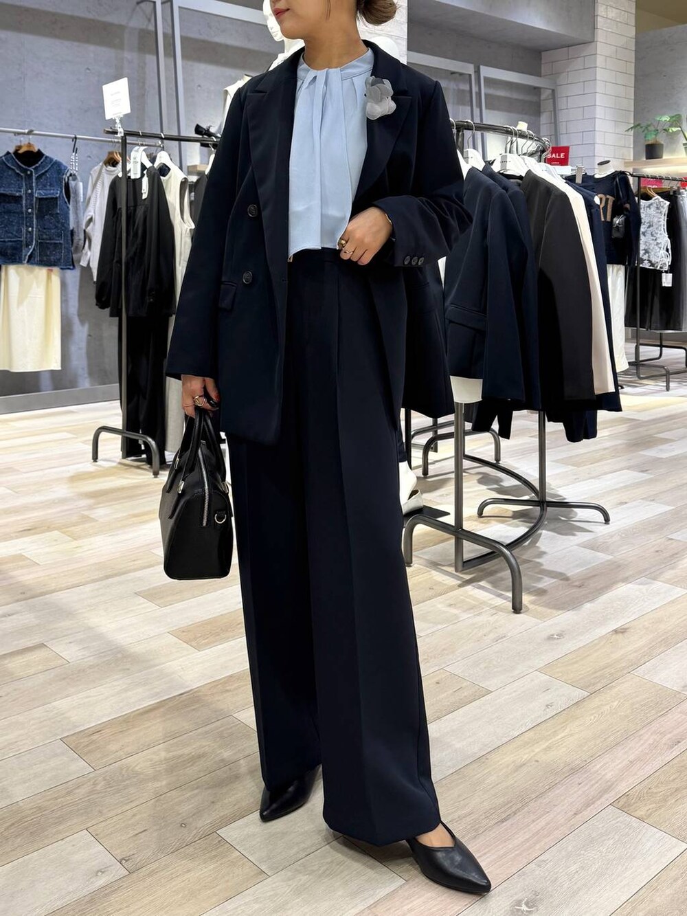 ブルー系のスーツパンツ、ブルー系のシャツ/ブラウス、ブラック系のパンプスを着用したレディースの冬コーディネートの5枚目の写真