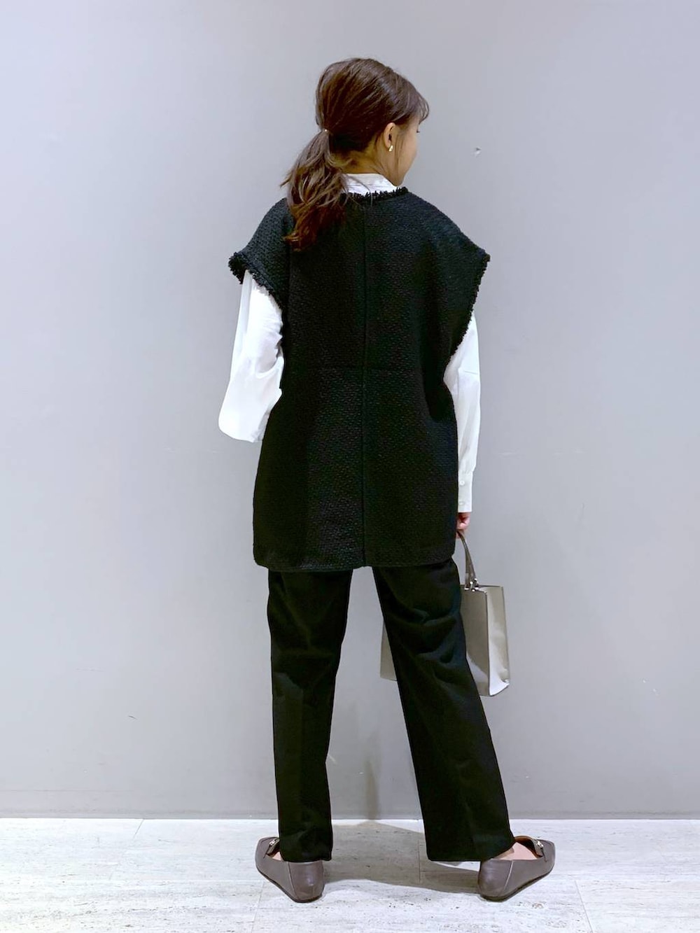 ブラック系のその他パンツ、ブラウン系のローファー、ベージュ系のショルダーバッグを着用したレディースの秋コーディネートの3枚目の写真