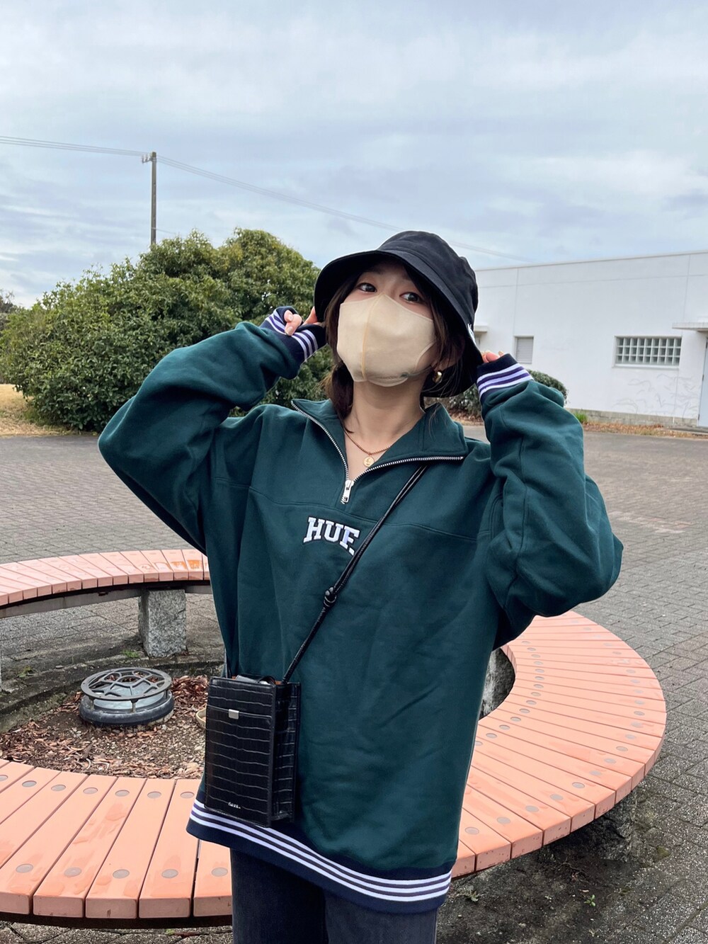 グリーン系のスウェット、その他のショルダーバッグ、ブラック系のデニムパンツを着用したレディースの春コーディネートの4枚目の写真