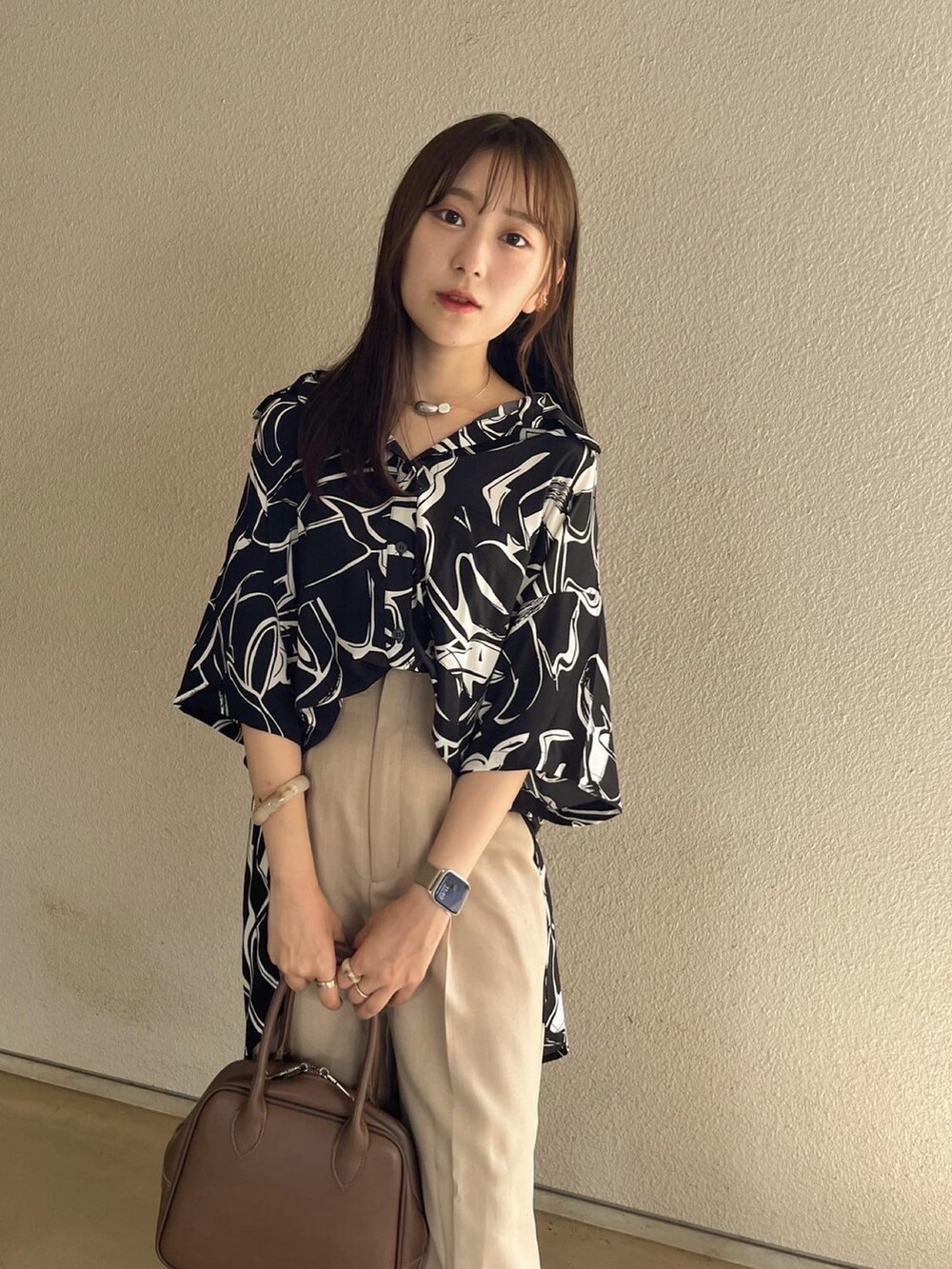 ブラック系のシャツ/ブラウス、ブラック系のパンツ、ブラウン系のボストンバッグを着用したレディースの夏コーディネートの2枚目の写真