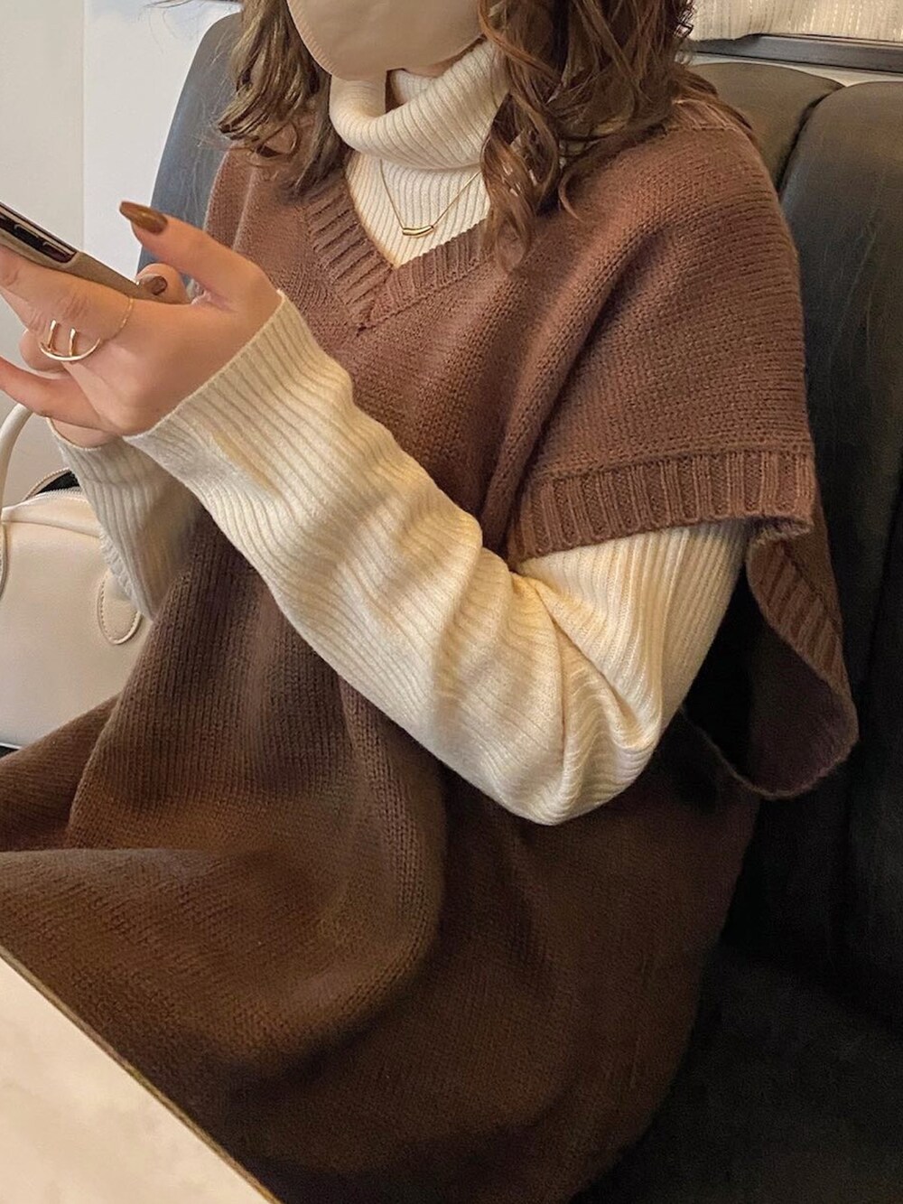 ホワイト系のニット/セーター、ブラウン系のワンピース、ホワイト系のその他アウターを着用したレディースの冬コーディネートの2枚目の写真