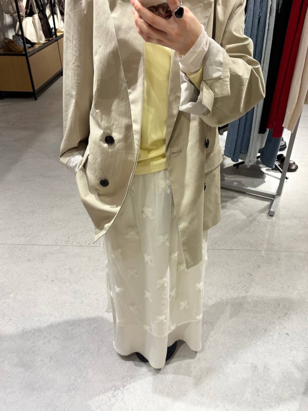 ホワイト系のスカート、ブラック系のローファー、ベージュ系のその他アウターを着用したレディースの春コーディネートの4枚目の写真