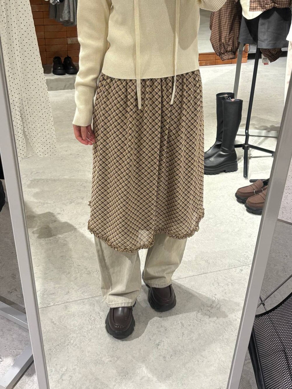 ベージュ系のデニムパンツ、ブラウン系のローファー、ホワイト系のニット/セーターを着用したレディースの冬コーディネートの3枚目の写真