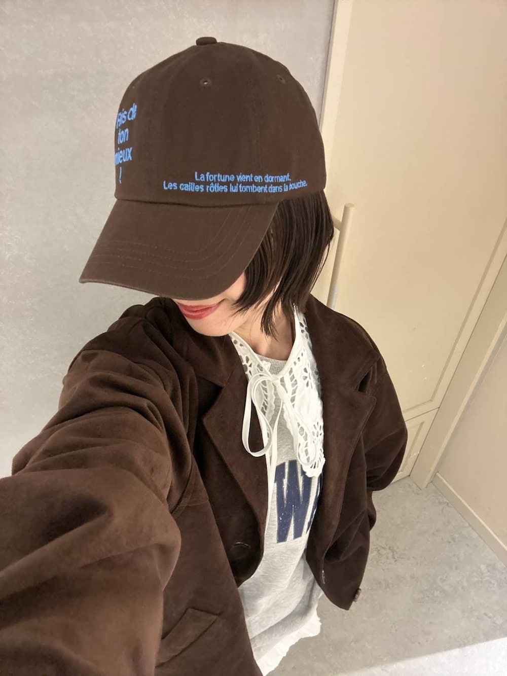 ブラウン系のローファー、ホワイト系のスカート、ブラウン系のテーラードジャケットを着用したレディースの冬コーディネートの2枚目の写真