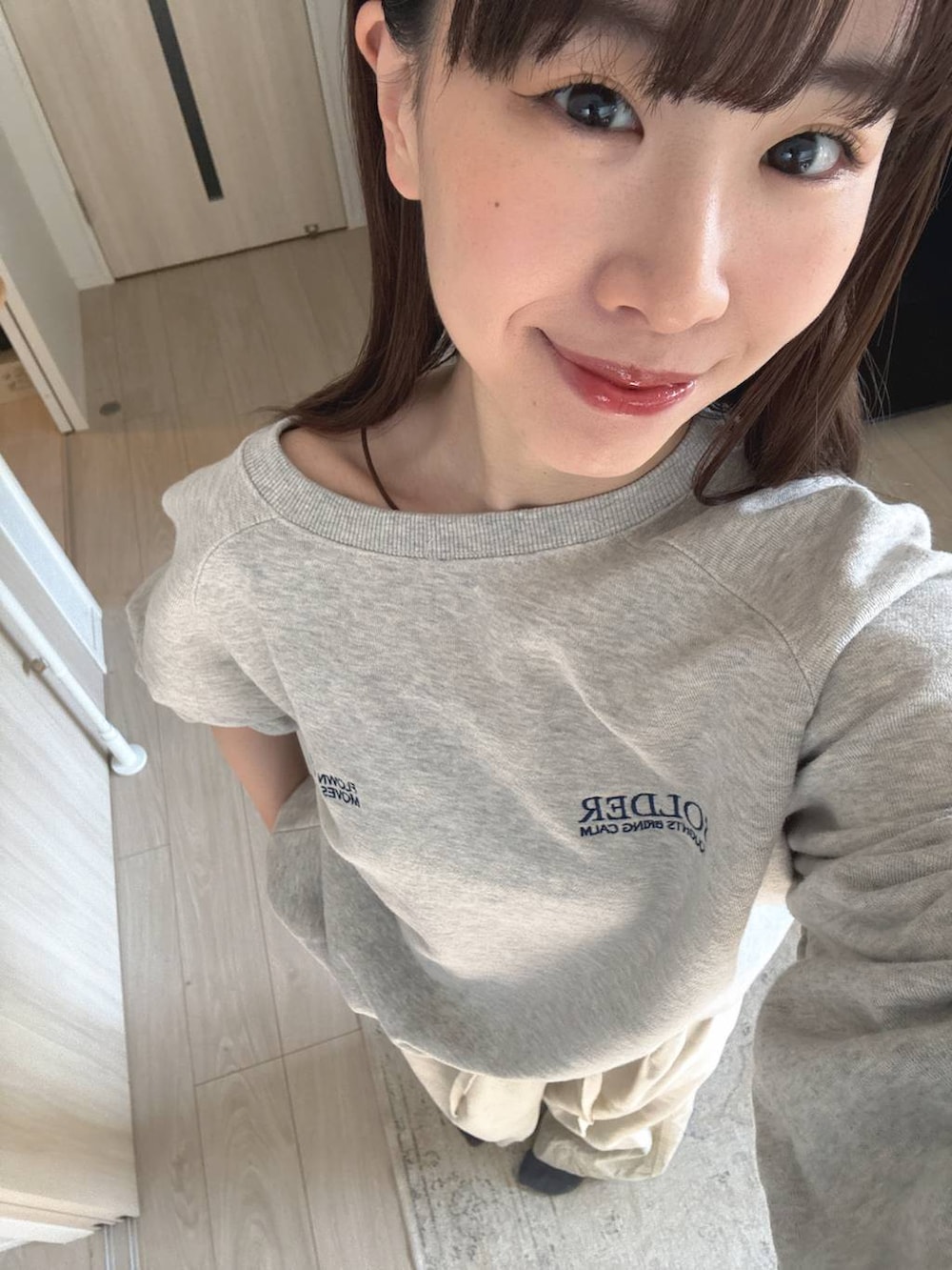 ホワイト系のデニムパンツ、グレー系のスウェットを着用したレディースの冬コーディネートの2枚目の写真