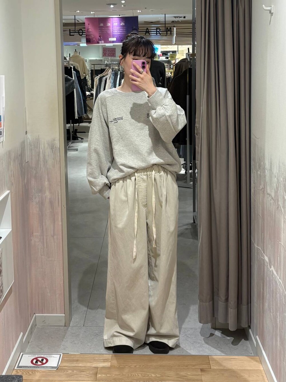 ホワイト系のデニムパンツ、グレー系のスウェットを着用したレディースの冬コーディネートの3枚目の写真