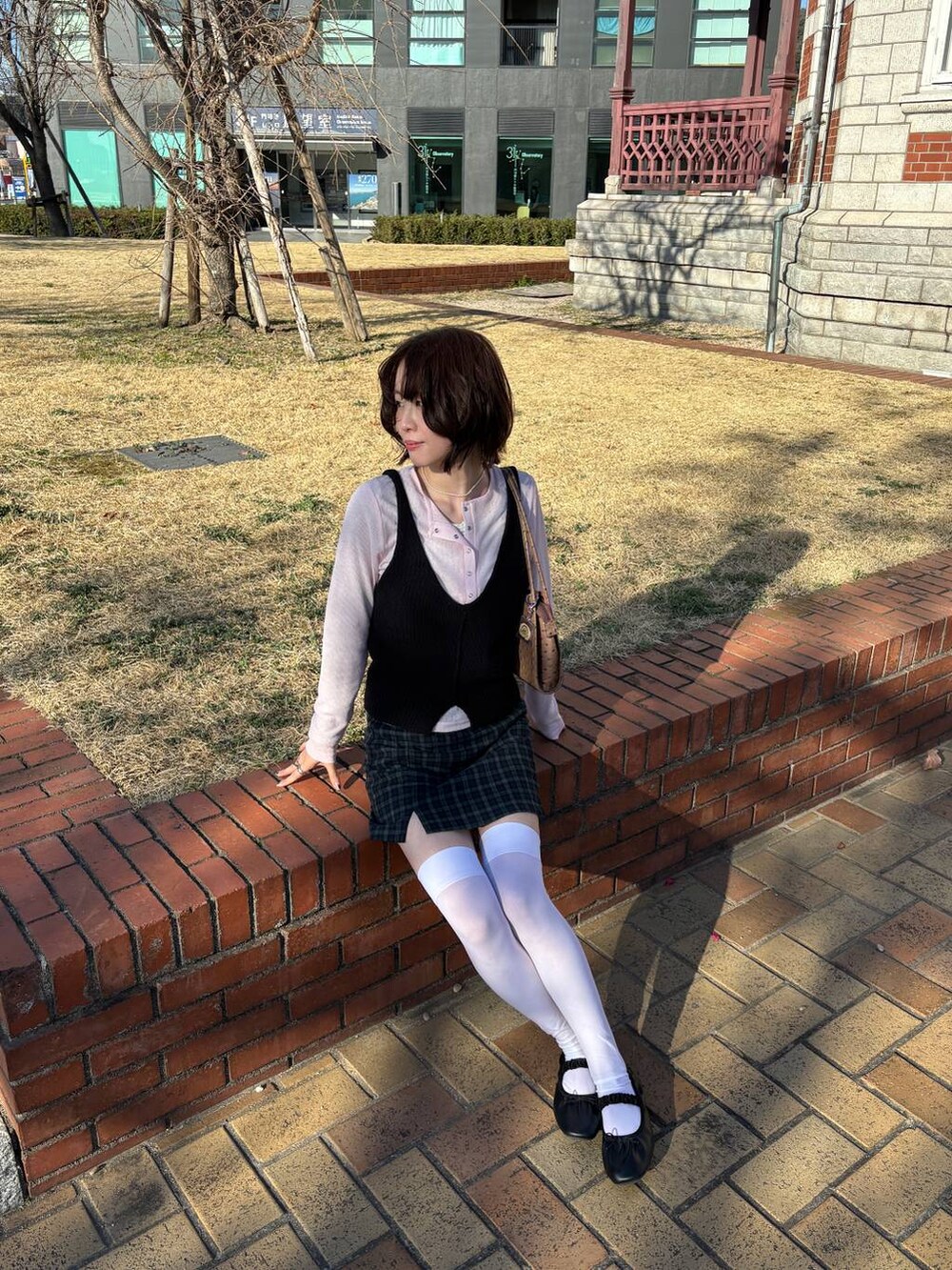 ピンク系のTシャツ/カットソー、ブラック系のニット/セーターを着用したレディースの冬コーディネートの2枚目の写真