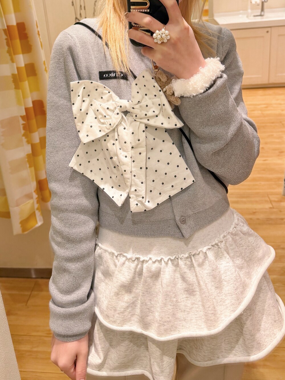 グレー系のカーディガン/ボレロ、シルバー系のスニーカー、ホワイト系のその他を着用したレディースの冬コーディネートの2枚目の写真