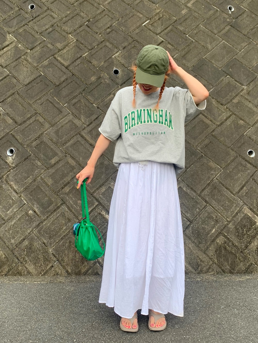 グレー系のTシャツ/カットソー、ホワイト系のスカート、ベージュ系のサンダルを着用したレディースの秋コーディネートの2枚目の写真