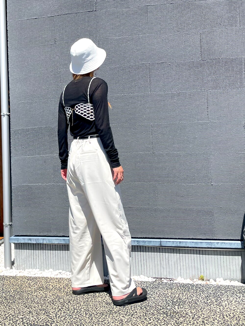 ブラック系のTシャツ/カットソー、ホワイト系のその他パンツ、ブラック系のボディバッグ/ウエストポーチを着用したレディースの秋コーディネートの3枚目の写真