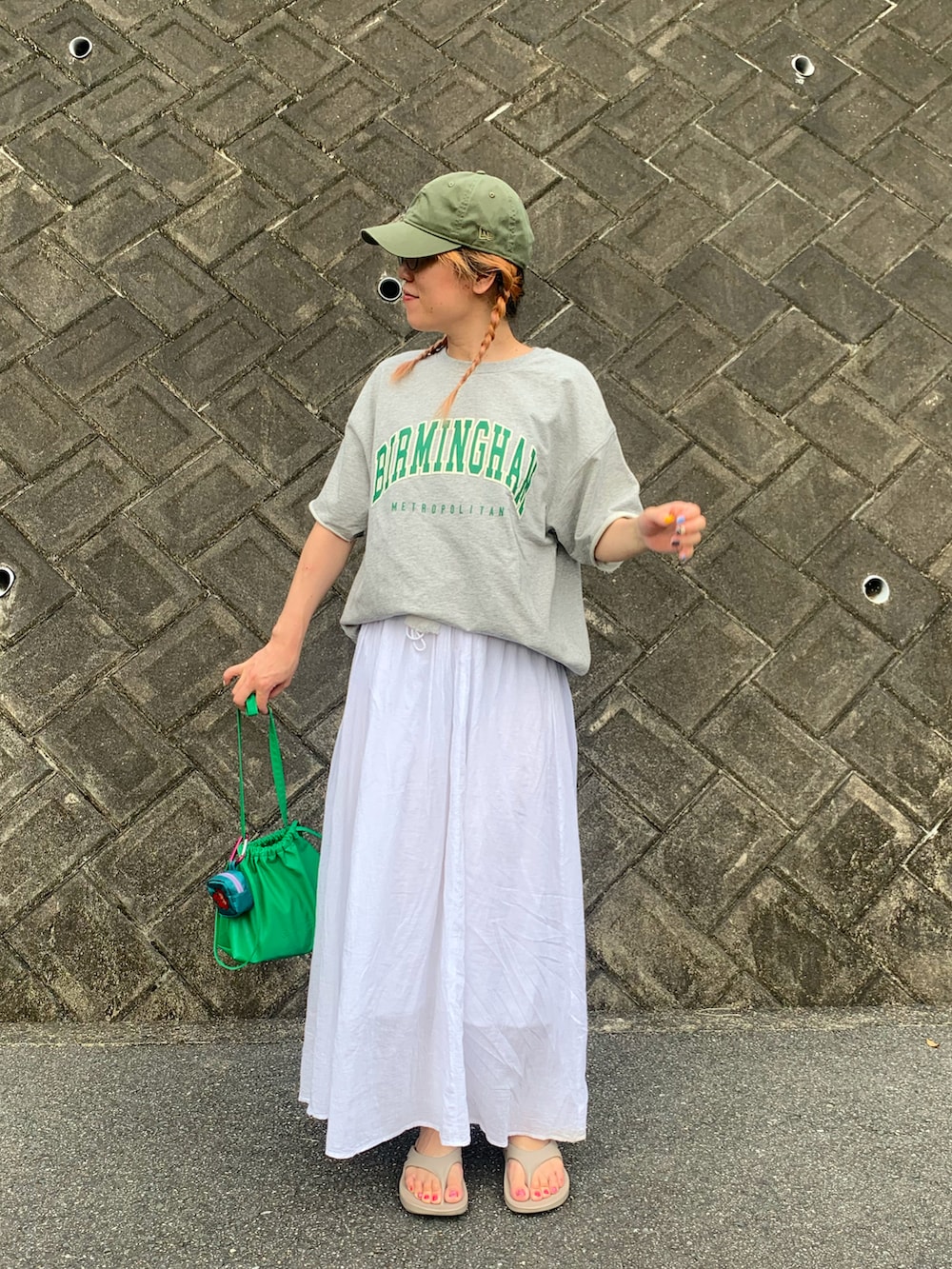 グレー系のTシャツ/カットソー、ホワイト系のスカート、ベージュ系のサンダルを着用したレディースの秋コーディネートの3枚目の写真