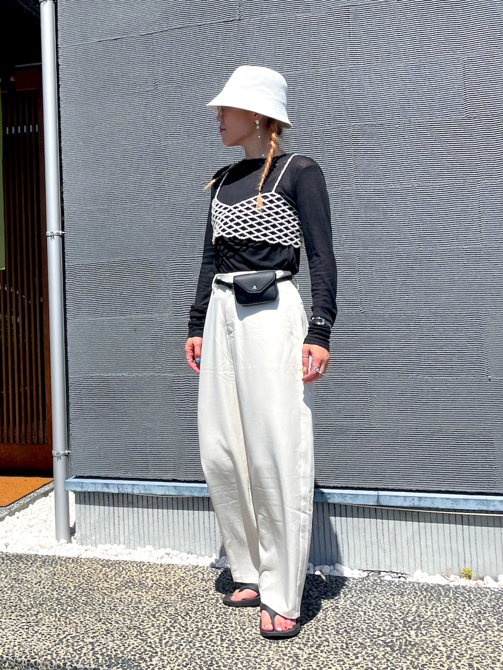 ブラック系のTシャツ/カットソー、ホワイト系のその他パンツ、ブラック系のボディバッグ/ウエストポーチを着用したレディースの秋コーディネートの2枚目の写真