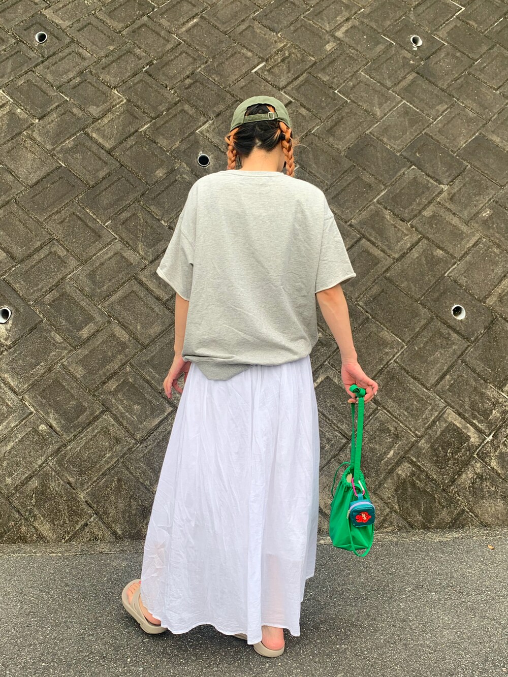 グレー系のTシャツ/カットソー、ホワイト系のスカート、ベージュ系のサンダルを着用したレディースの秋コーディネートの5枚目の写真