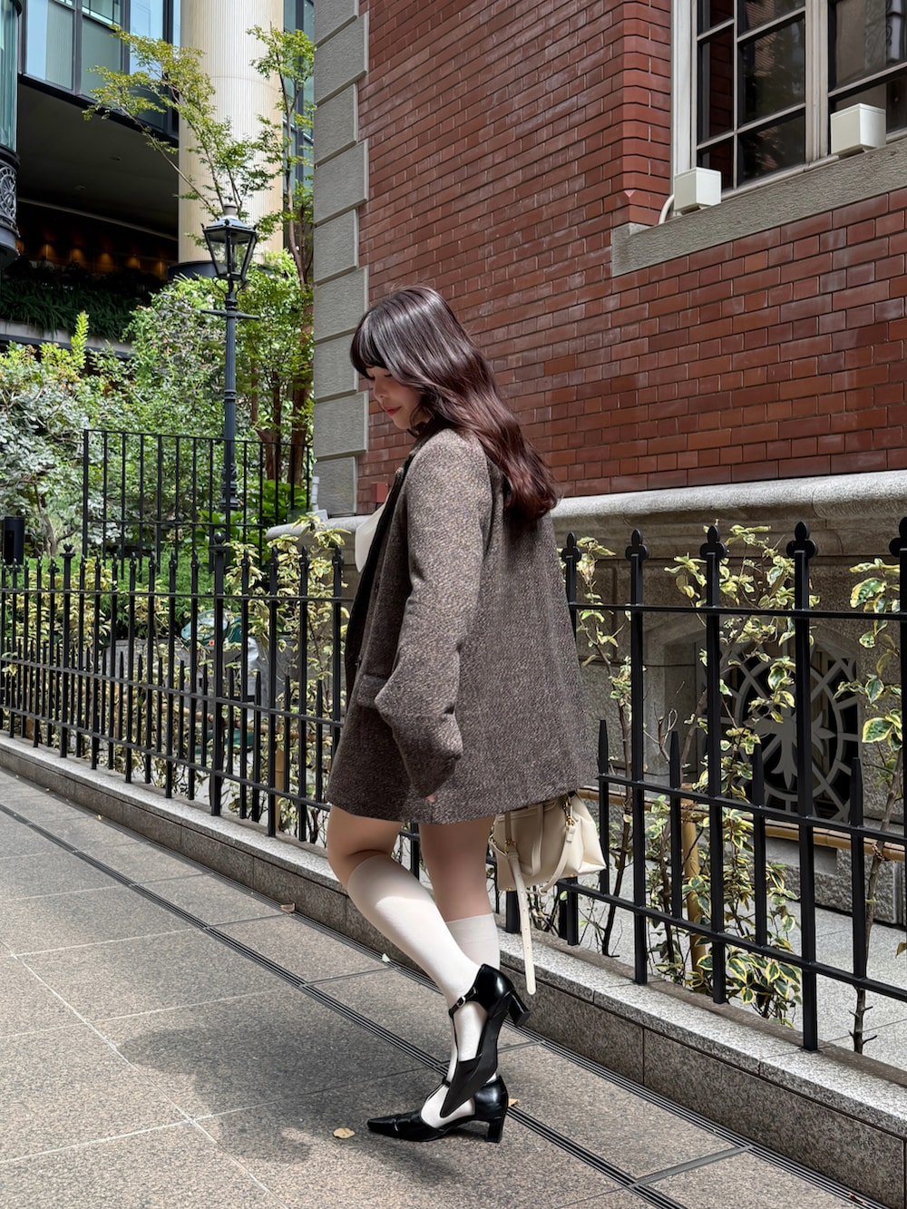 ブラウン系のテーラードジャケット、ブラウン系のスカートを着用したレディースの秋コーディネートの3枚目の写真