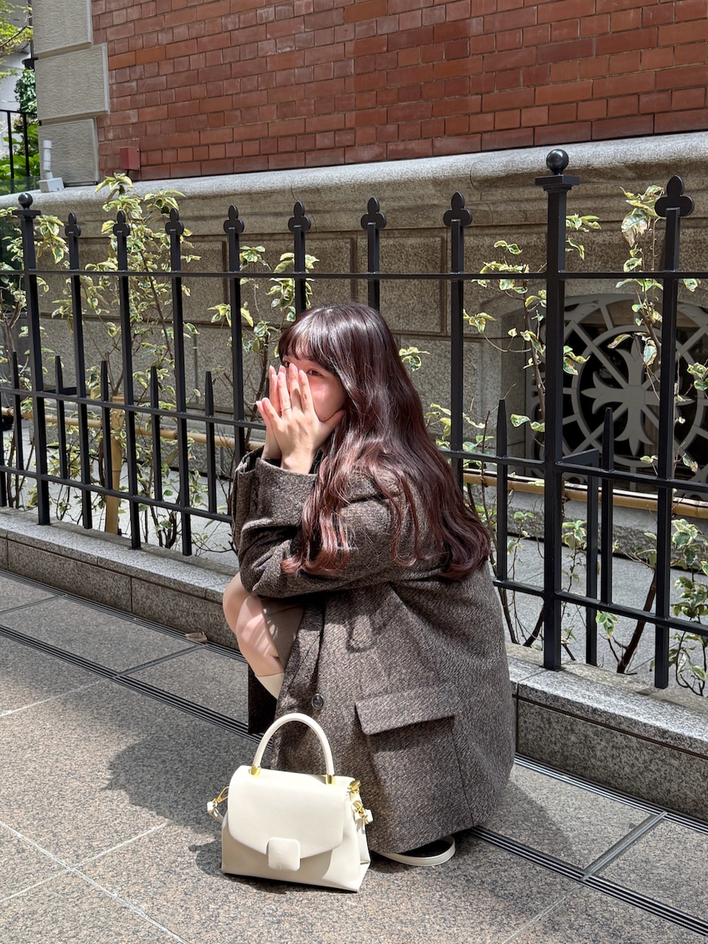 ブラウン系のテーラードジャケット、ブラウン系のスカートを着用したレディースの秋コーディネートの2枚目の写真