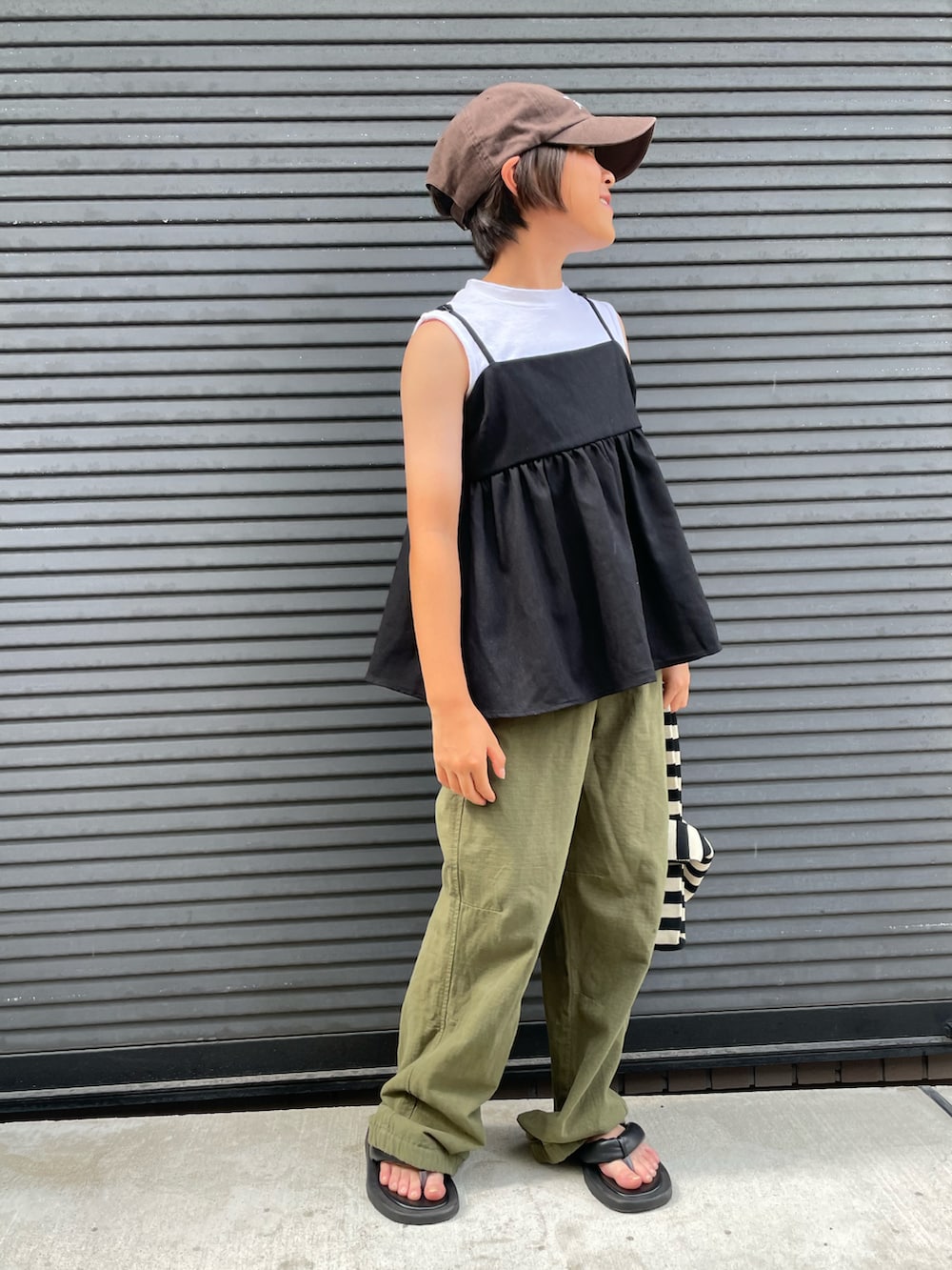 ブラック系のキャミソール、グリーン系のカーゴパンツ、ホワイト系のタンクトップを着用したキッズの夏コーディネートの3枚目の写真