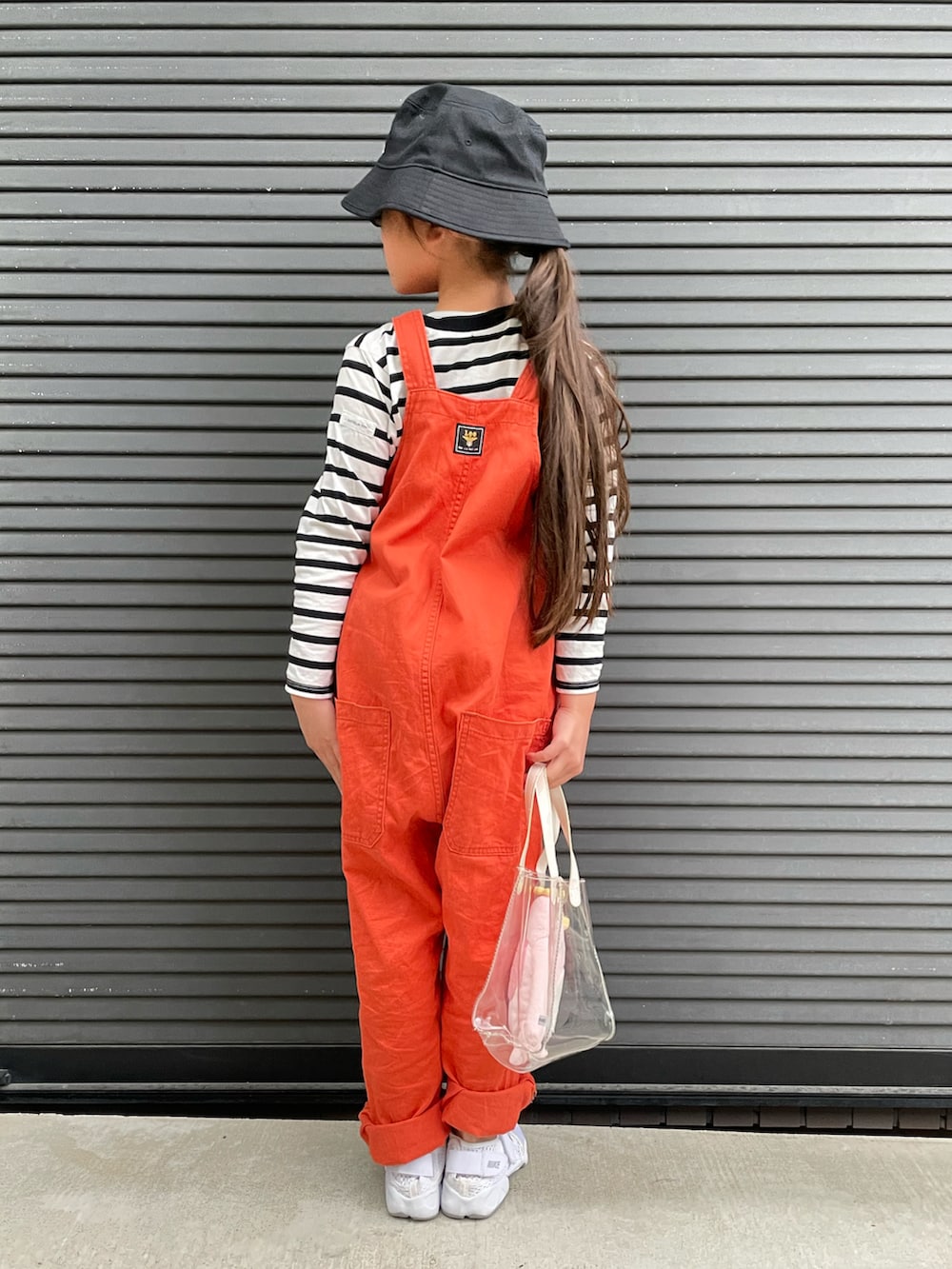オレンジ系のサロペット/オーバーオール、ホワイト系のTシャツ/カットソー、その他のトートバッグを着用したキッズの春コーディネートの3枚目の写真