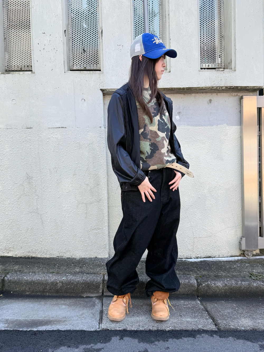 ブラック系のブルゾン、ベージュ系のブーツ、グリーン系のTシャツ/カットソーを着用したレディースの冬コーディネートの2枚目の写真