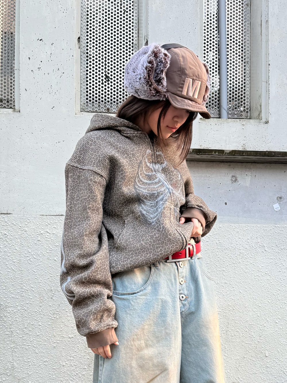 ブラック系のスニーカー、ブルー系のデニムパンツ、その他のパーカーを着用したレディースの冬コーディネートの2枚目の写真