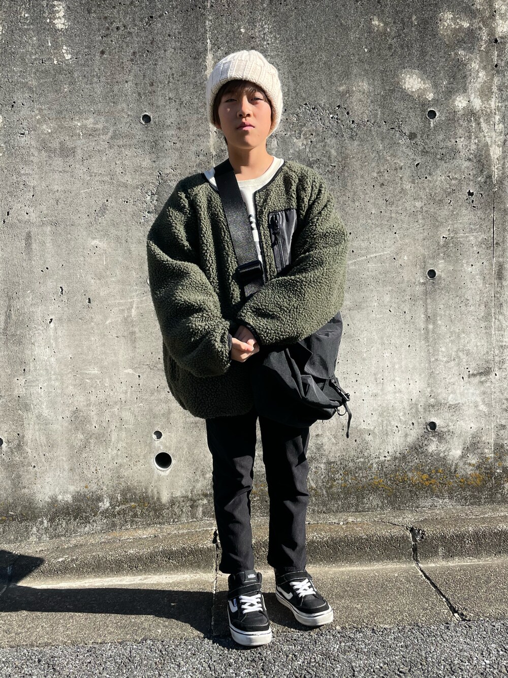 グリーン系のその他アウター、ホワイト系のスウェット、ブラック系のその他パンツを着用したキッズの冬コーディネートの4枚目の写真