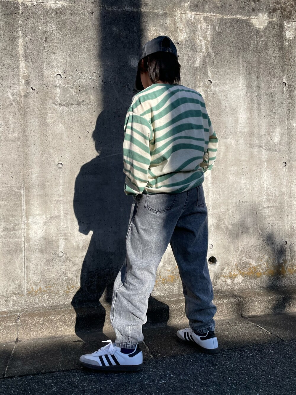 グリーン系のTシャツ/カットソー、ブラック系のデニムパンツ、グリーン系のショルダーバッグを着用したキッズの春コーディネートの2枚目の写真